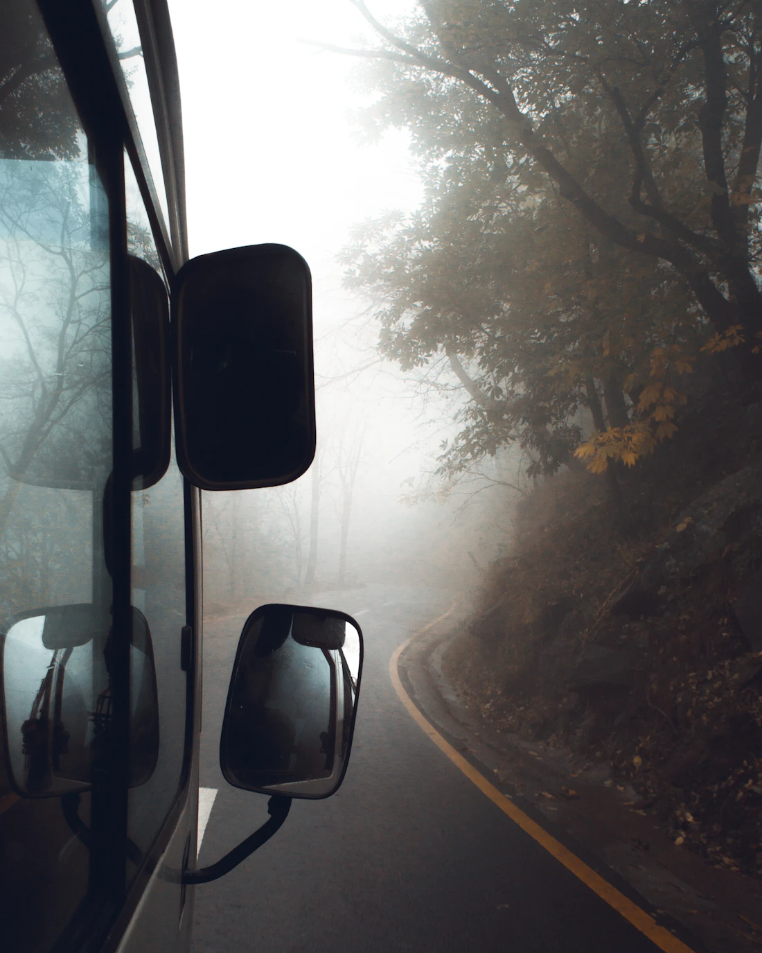 Car on a foggy forest road in Murree