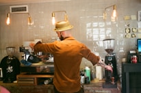 Barista preparing a fresh cup of coffee surrounded by rustic decor and natural elements