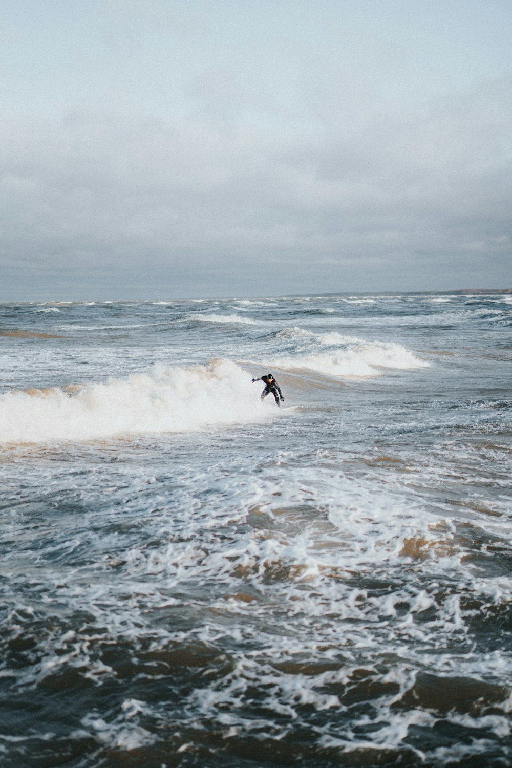 person surfing on sea wave during daytime