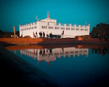 reflection of white building on body of water