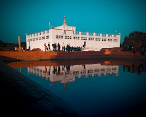 reflection of white building on body of water