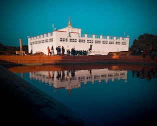 reflection of white building on body of water
