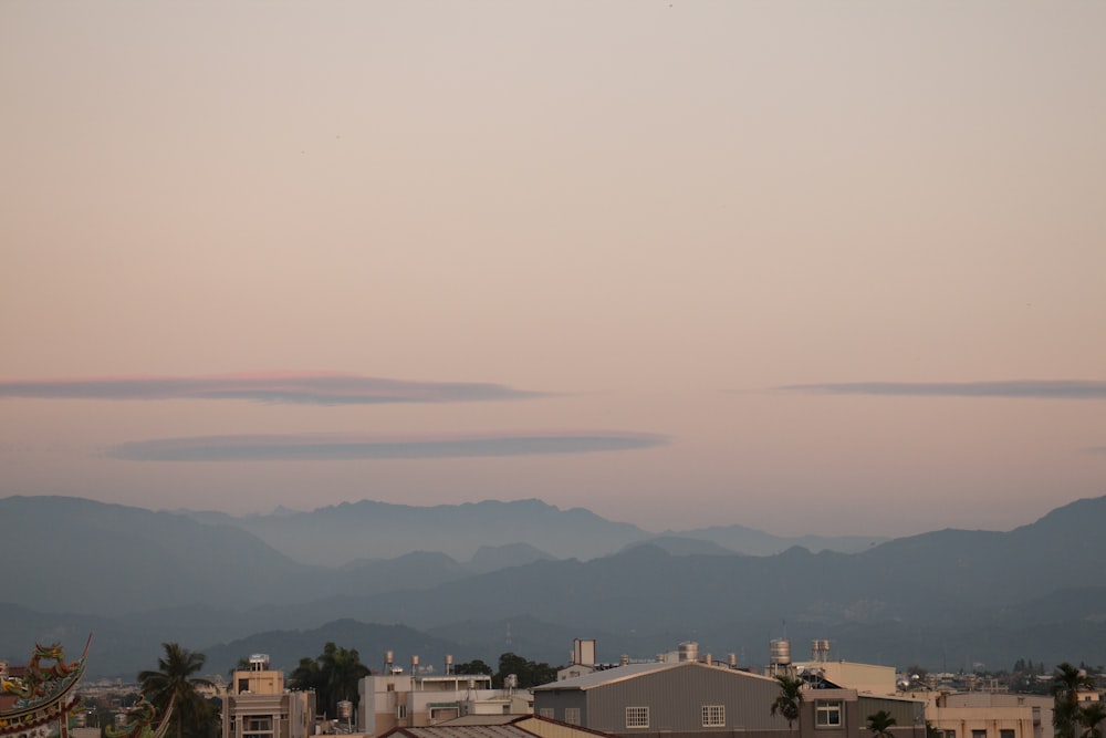 houses and mountains under white sky