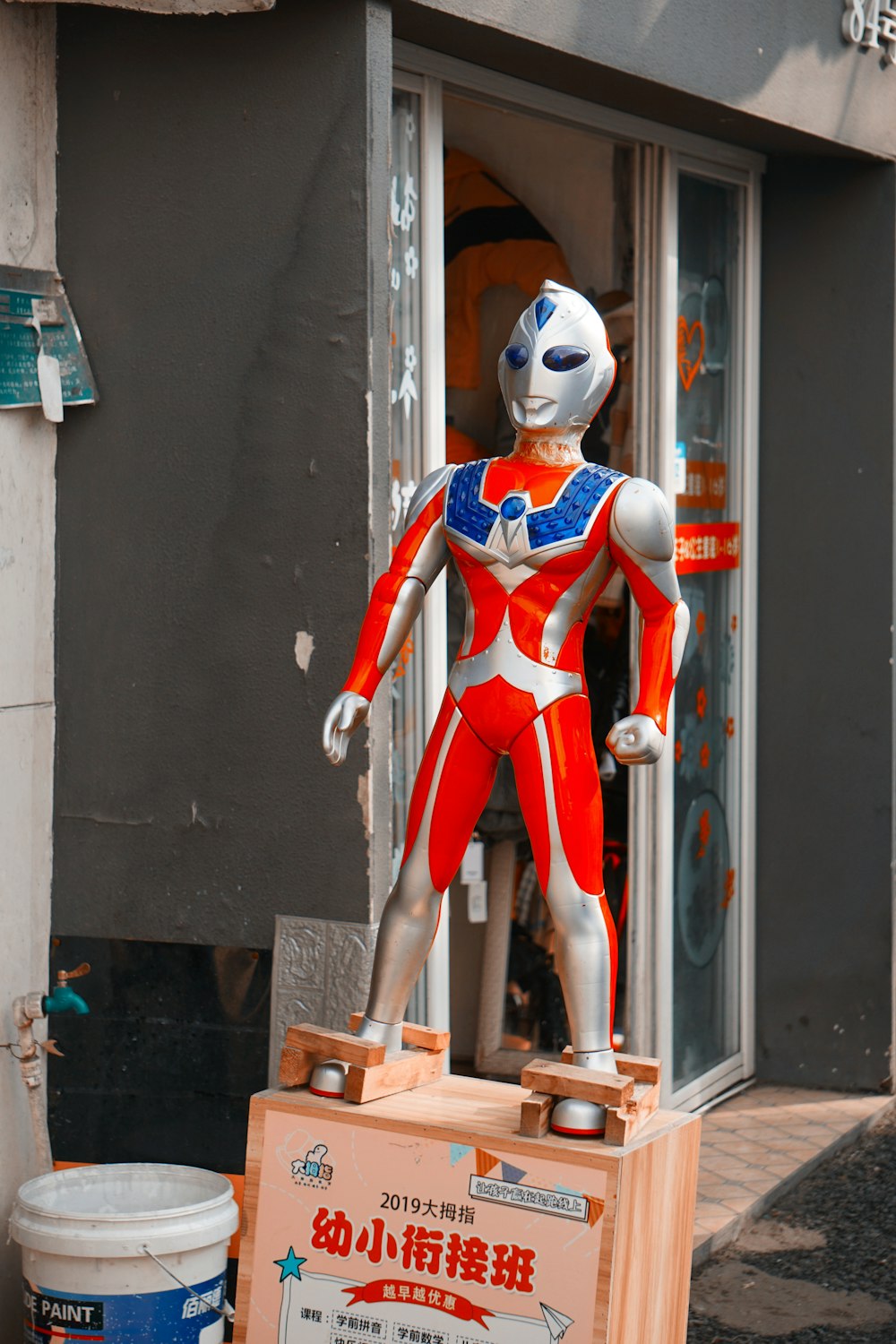 man in red and white power ranger costume standing on brown wooden seat