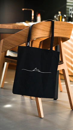 Close-up of a sleek, custom tote bag with minimalist design on a wooden table.