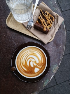 coffee on saucer near drinking glass on top of outdoor table