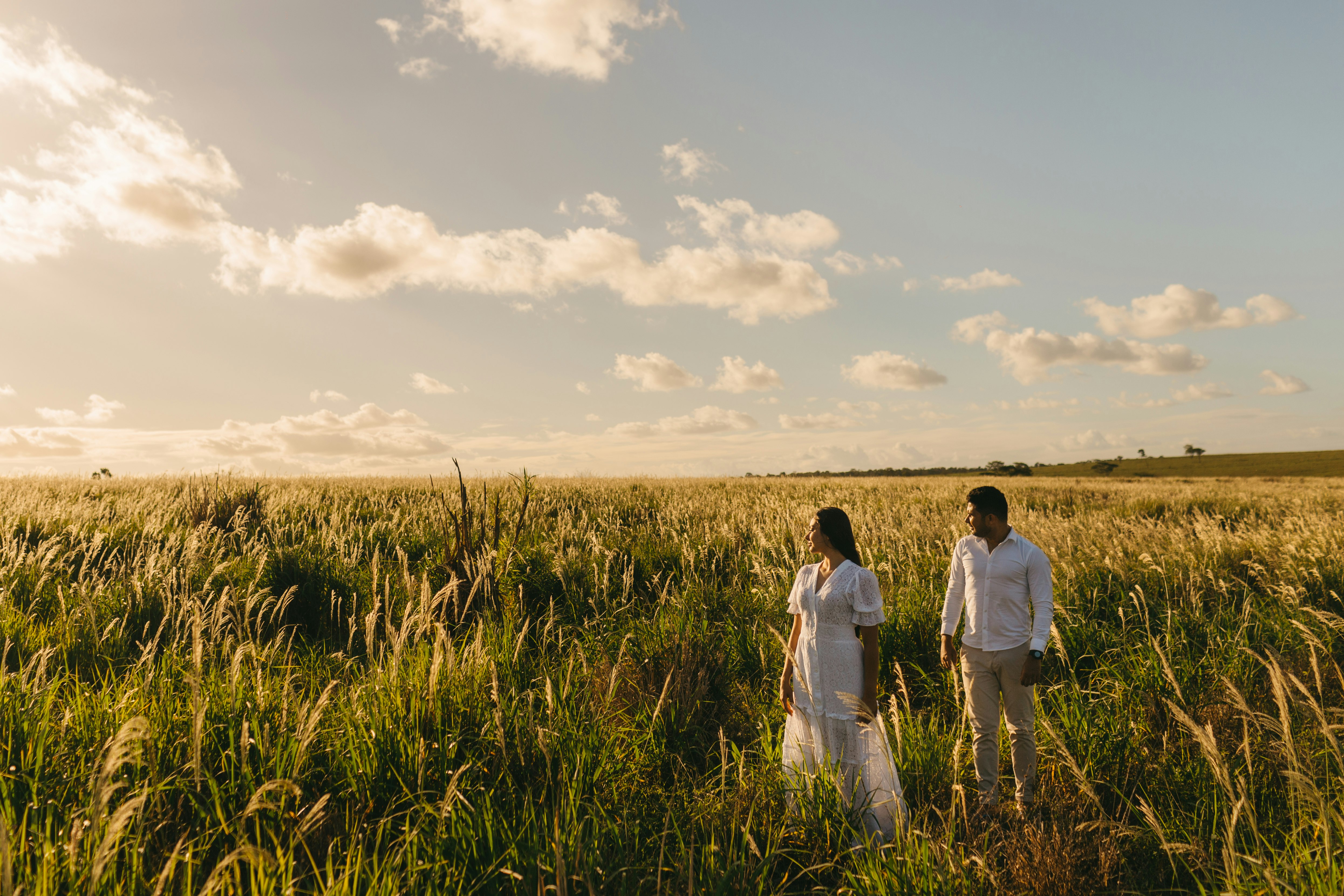 man and woman standing near grass field during daytime