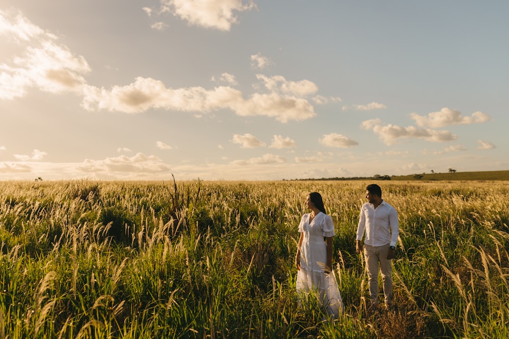 man and woman standing near grass field during daytime