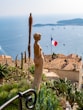woman brown statue with view of France flag during daytime