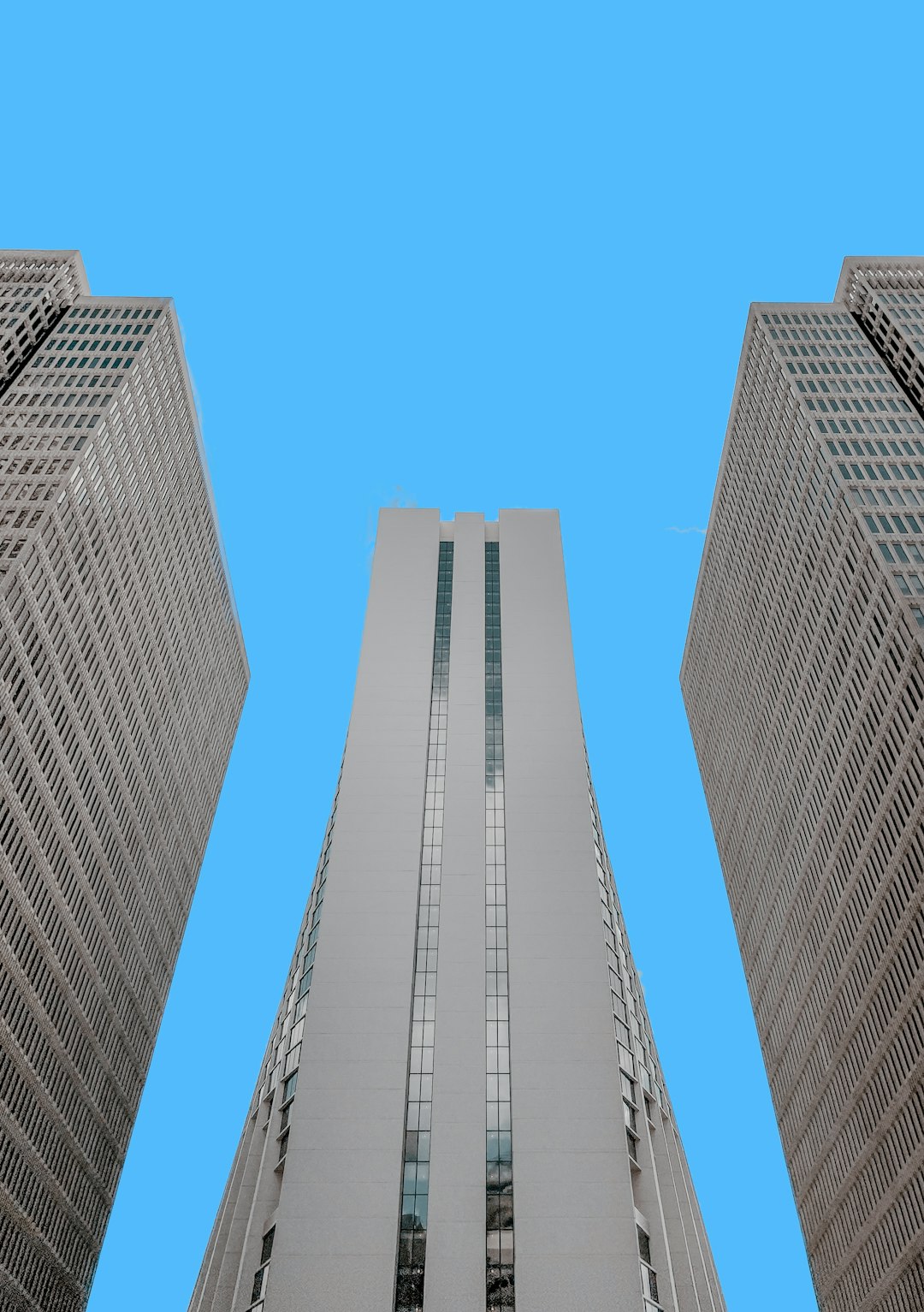 low-angle photo of white high-rise building under blue sky