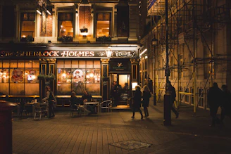 A cozy evening scene outside the Churchill Tap Pub with warm lights glowing and friends gathered at the entrance.
