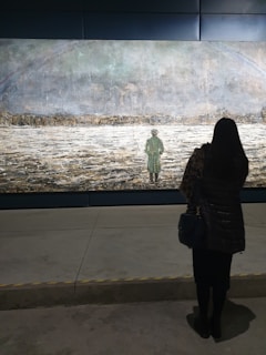 Large canvas painting featuring a lone figure walking into a misty horizon