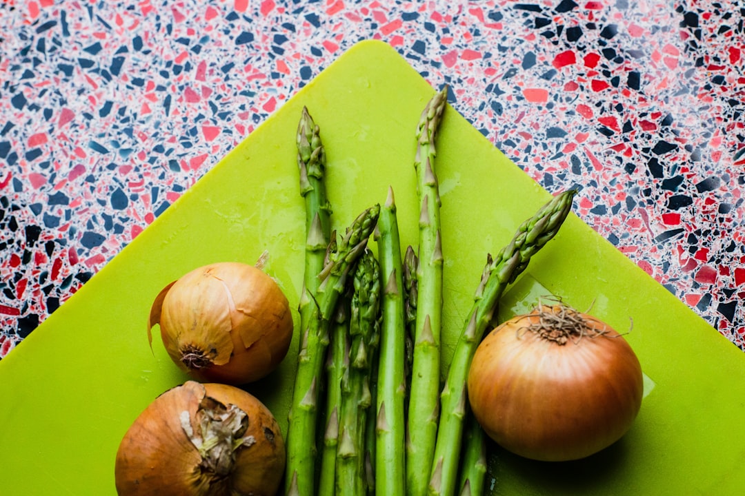 flat-lay photography of green asparagus and white onion bulbs