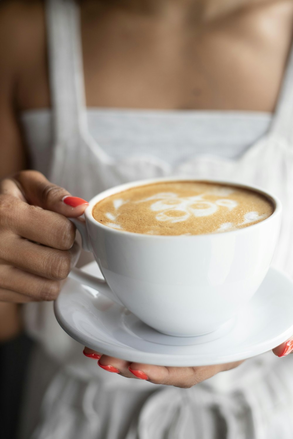 woman holding white ceramic teacup