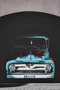 A gleaming vintage truck with a fresh custom paint job parked under soft garage lighting.