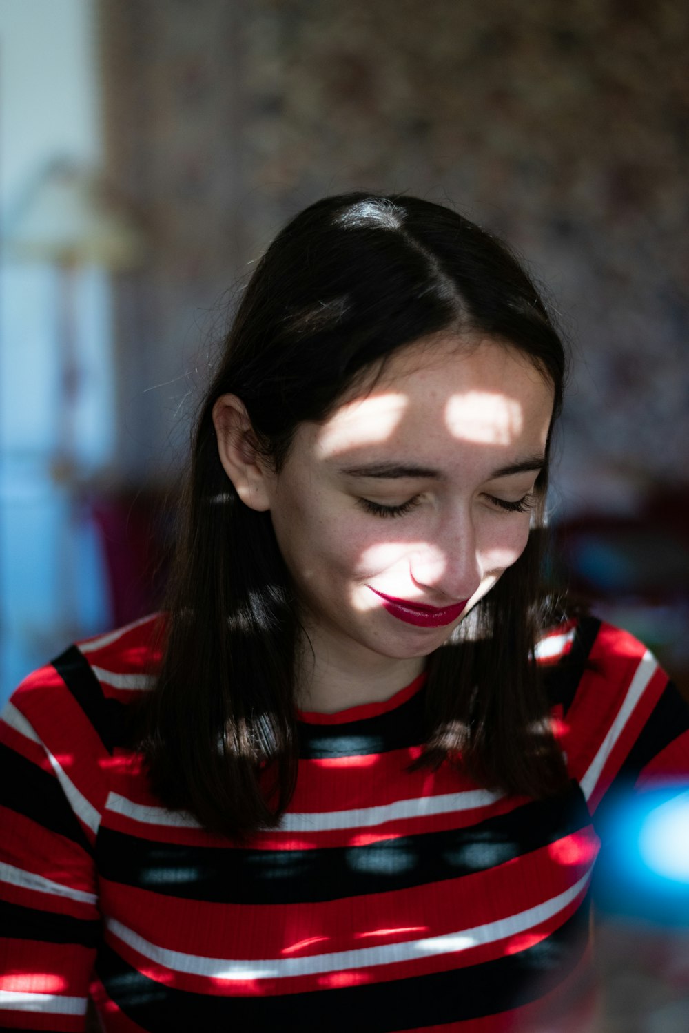 femme portant un chemisier à rayures rouges, noires et rouges