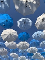white and blue umbrellas hanging during daytime
