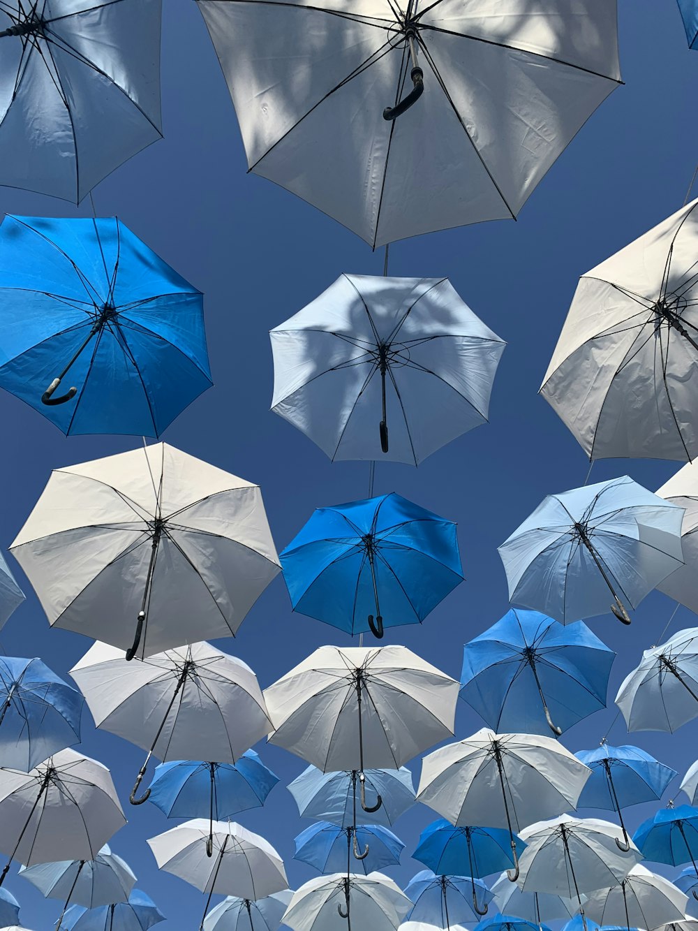 white and blue umbrellas hanging during daytime
