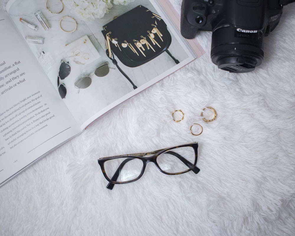 black framed eyeglasses beside book