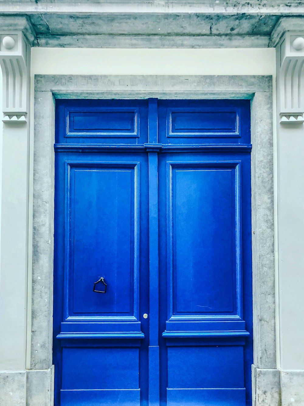 white building showing closed blue wooden panel door