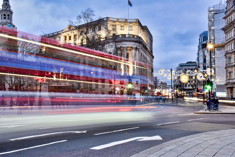 time lapse photography of people walking on road beside buildings