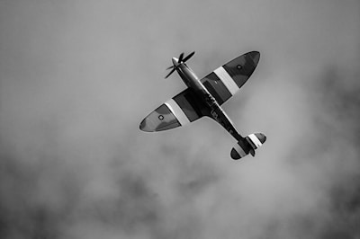 A dramatic shot of a vintage military aircraft soaring against a clear blue sky, highlighting intricate details.