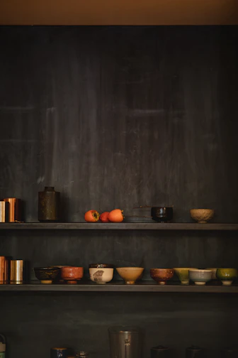 Brightly glazed ceramic bowls stacked with fresh fruit inside a cozy kitchen.