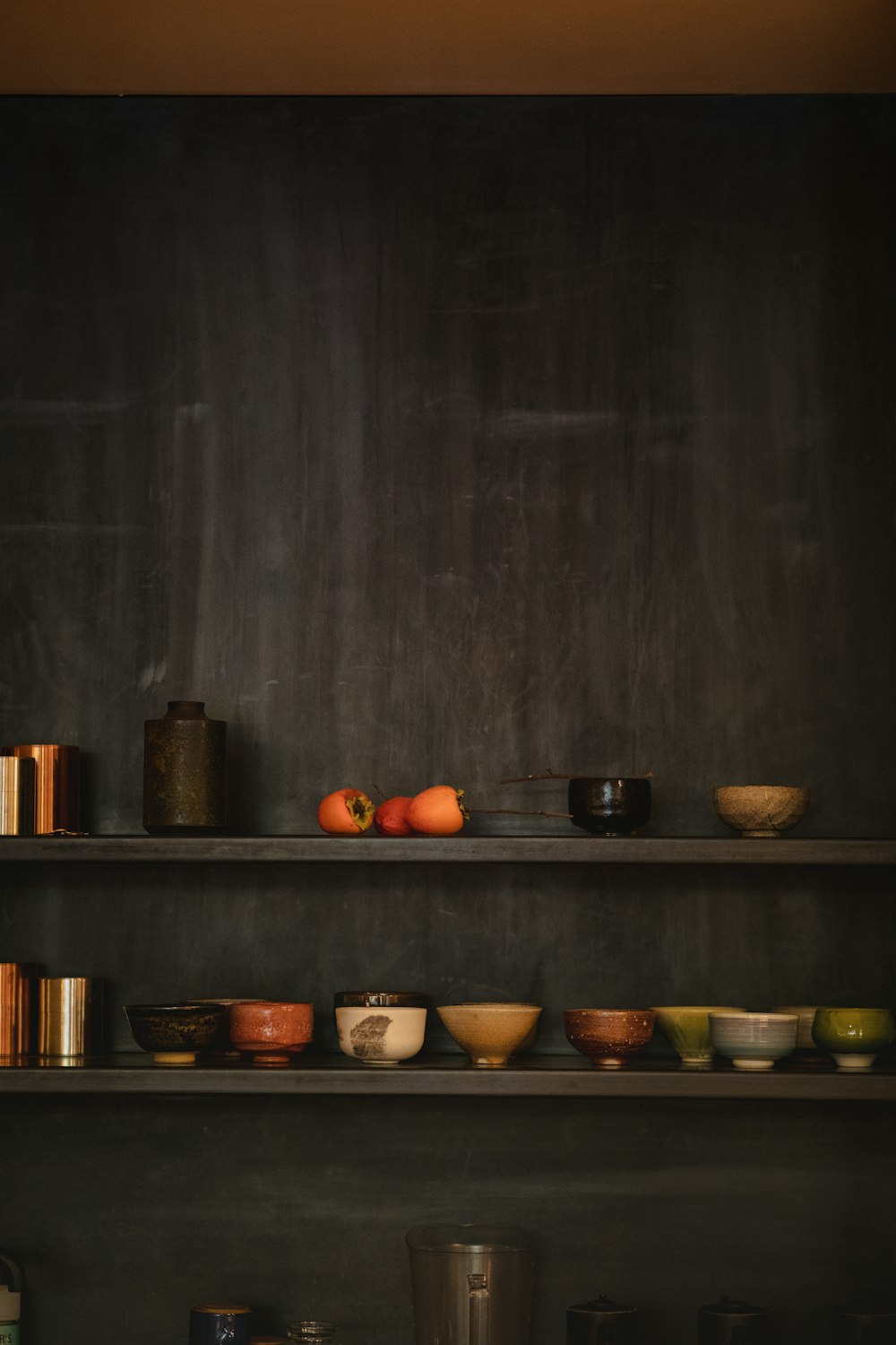 assorted ceramic vases, bowl, and figurines on black wooden shelf