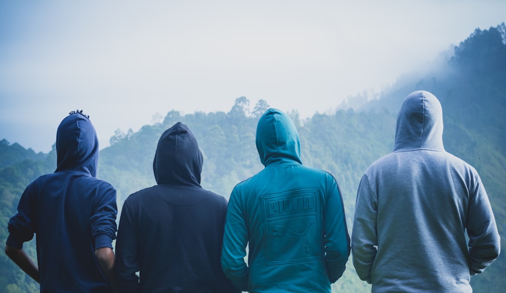 four person wearing pullover hoodies