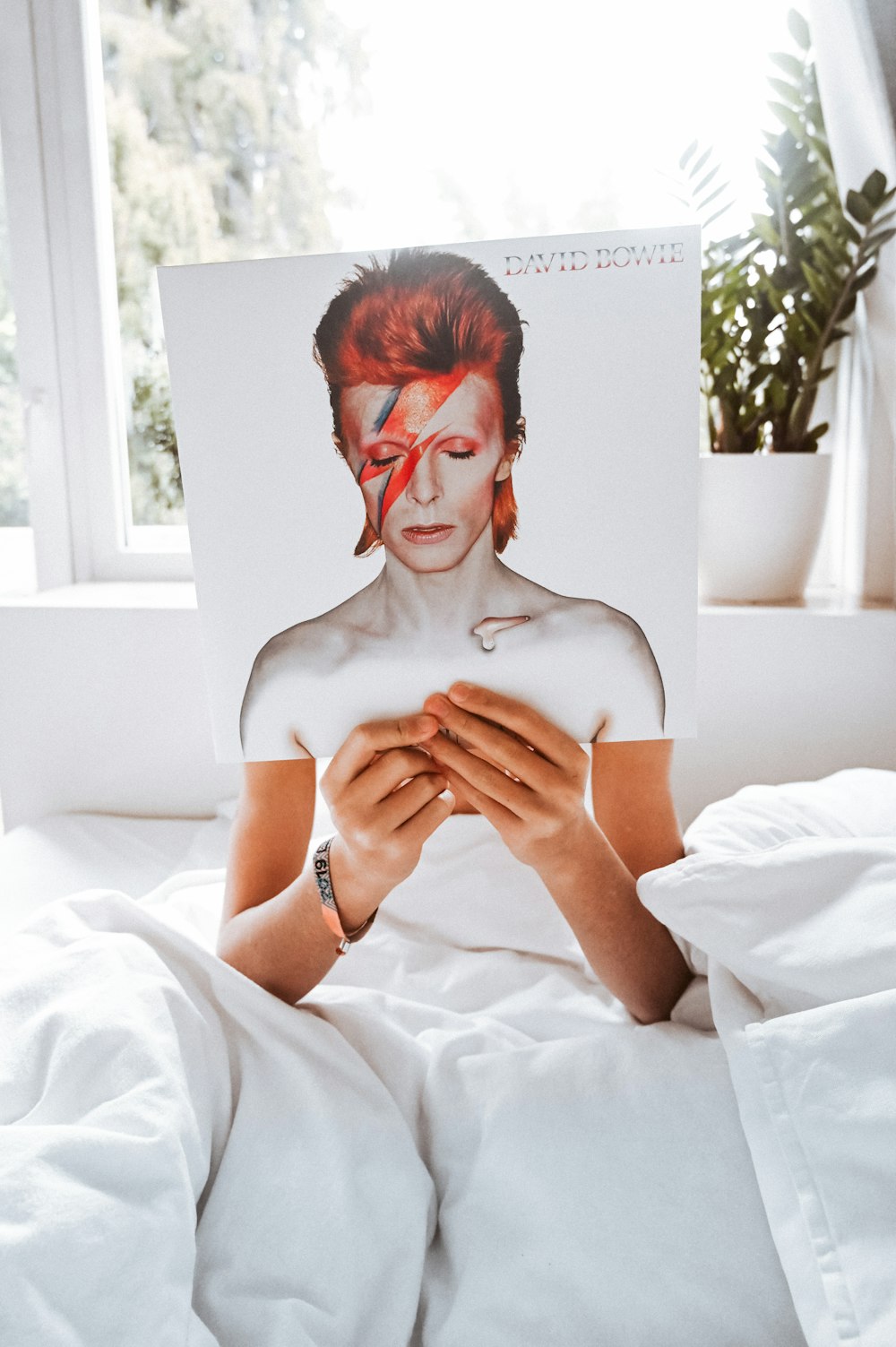 person sitting on bed reading book