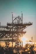 Wide shot of a large metal frame installation at a building site during sunset.