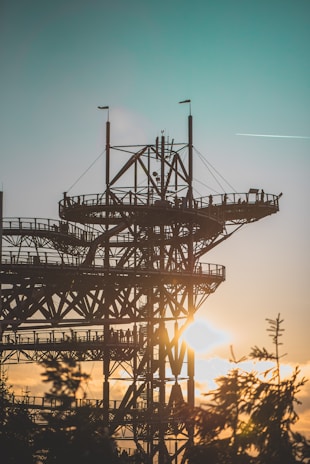 An artistic view of metal structures against a sunset backdrop.