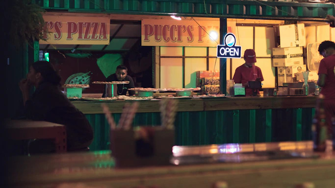 A cozy burger and pizza restaurant counter with a friendly staff ready to take orders.