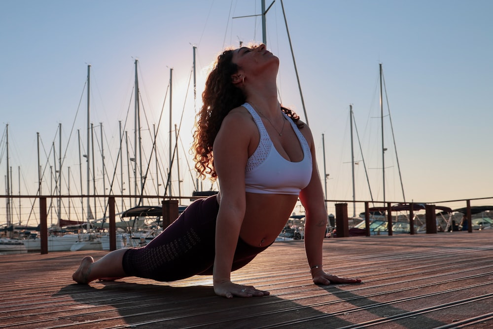 Frau trägt weißen Sport-BH und macht tagsüber Yoga auf dem Weg