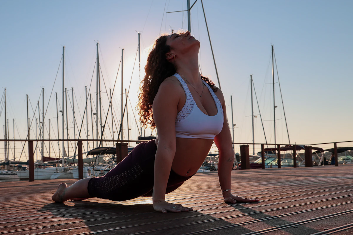 Yoga teacher trainee moving through upward-facing dog during a sunrise sun salutation practice