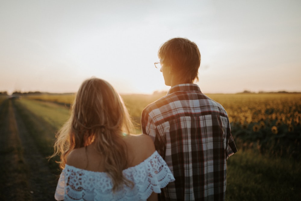 man and woman walking on field