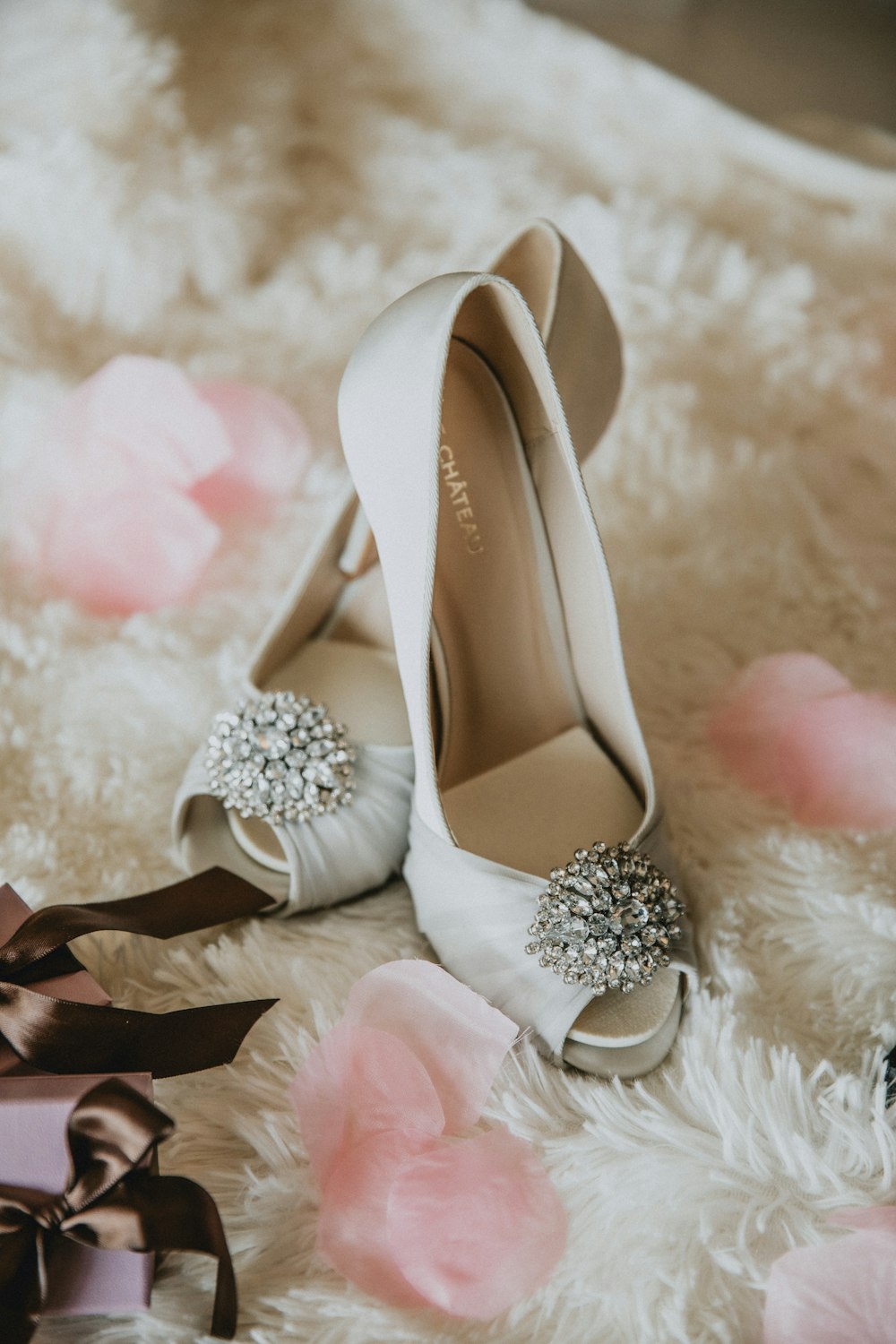 pair of white leather peep-toe heeled shoes with bow accent