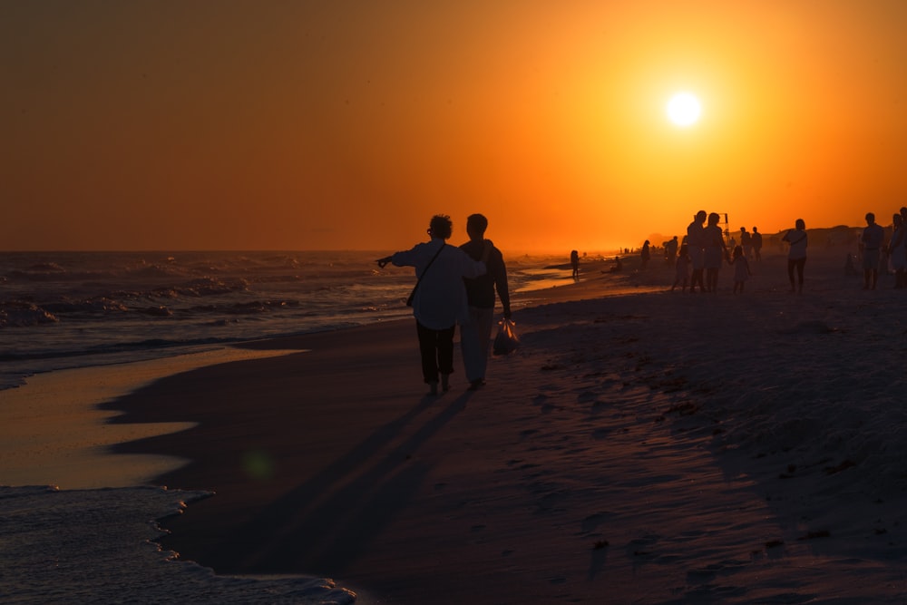 couple walking on shore during golden hour