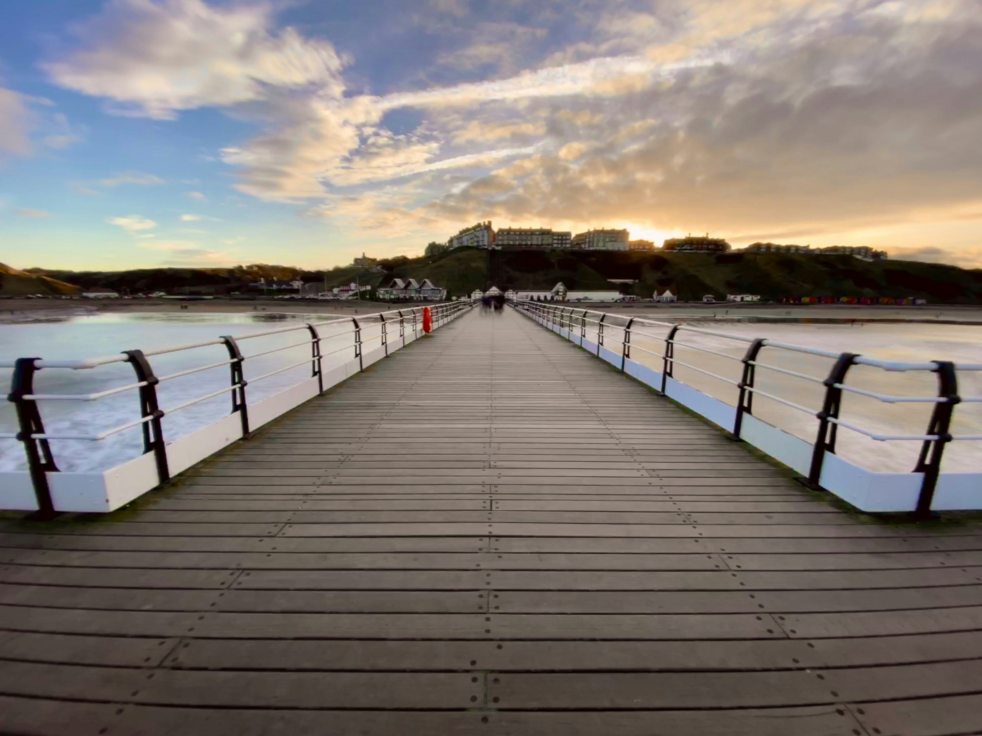 brown wooden ocean dock photograph, Saltburn Pier looking back towards Saltburn.