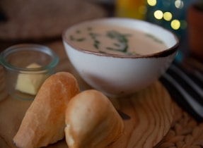 A warm and inviting image of a bowl of soup with bread.