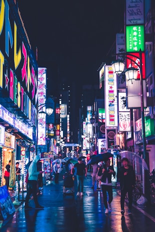 A bustling night scene in Tokyo with neon signs reflecting off wet streets.