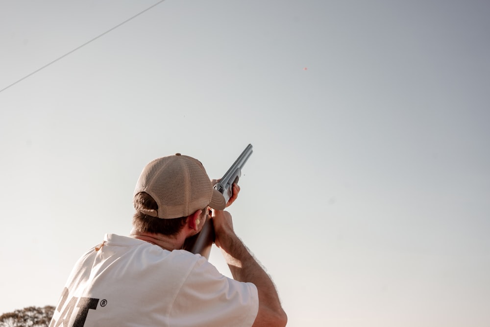 man pointing gun on sky