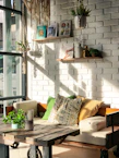 A rustic wooden bench stool placed beside a cozy reading nook with soft cushions.