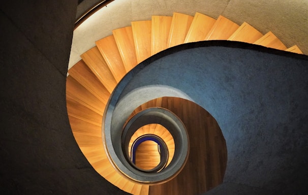 high-angle photo of brown wooden spiral staircase
