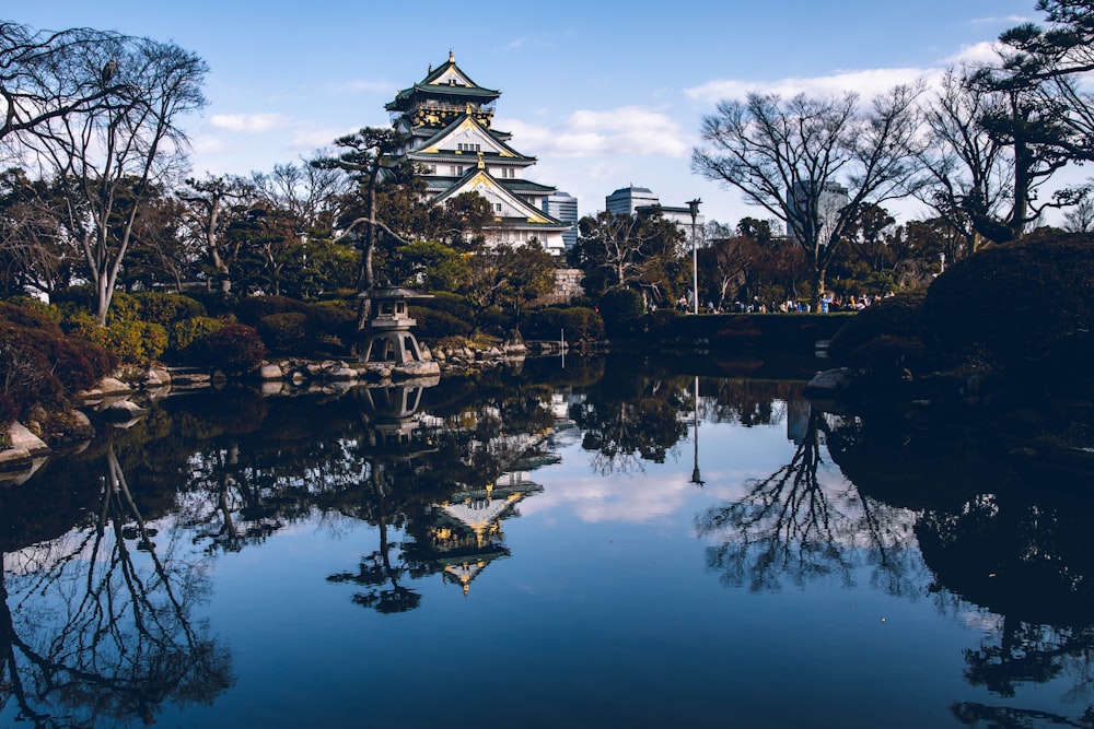 temple near trees and body of water during day