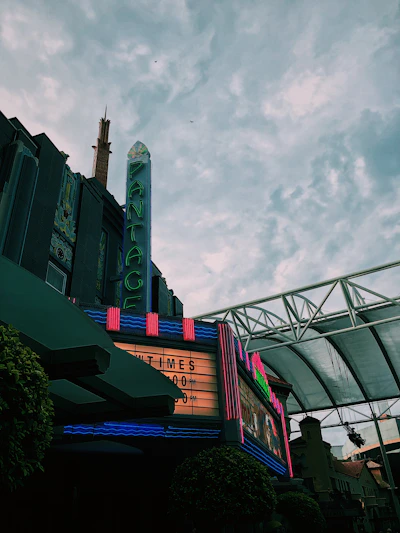 A warmly lit vintage movie theater marquee glowing at dusk, inviting locals inside.