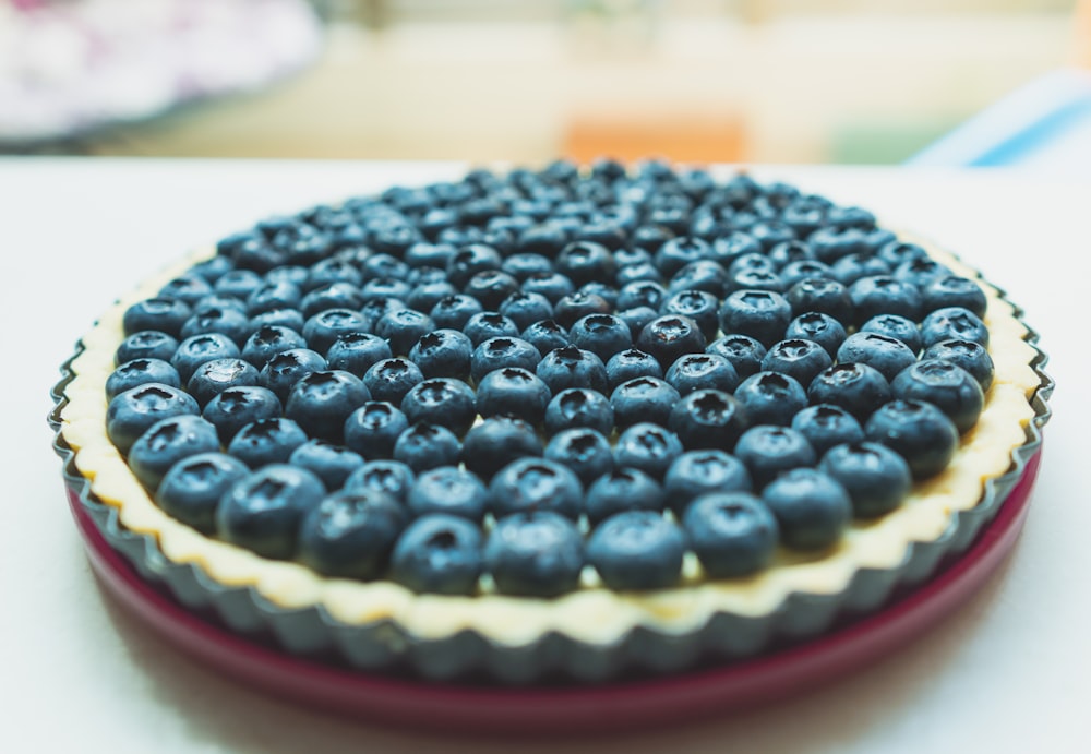 blueberry cheesecake on red base on white surface