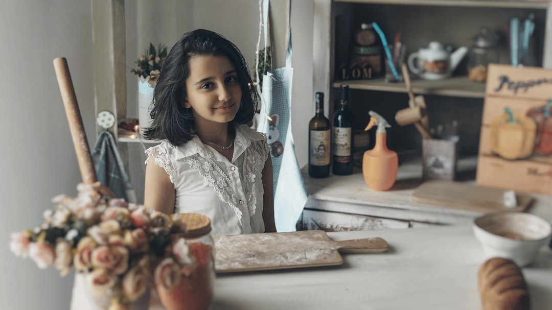 girl smiling and looking at the camera beside chopping board with flour