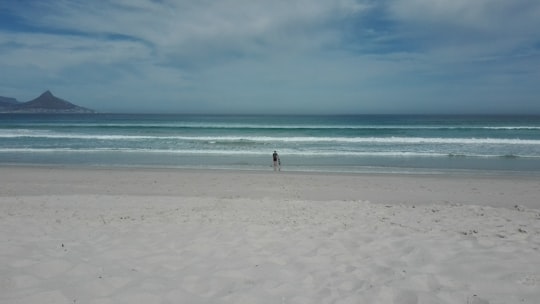 person standing on the seashore in Bloubergstrand South Africa