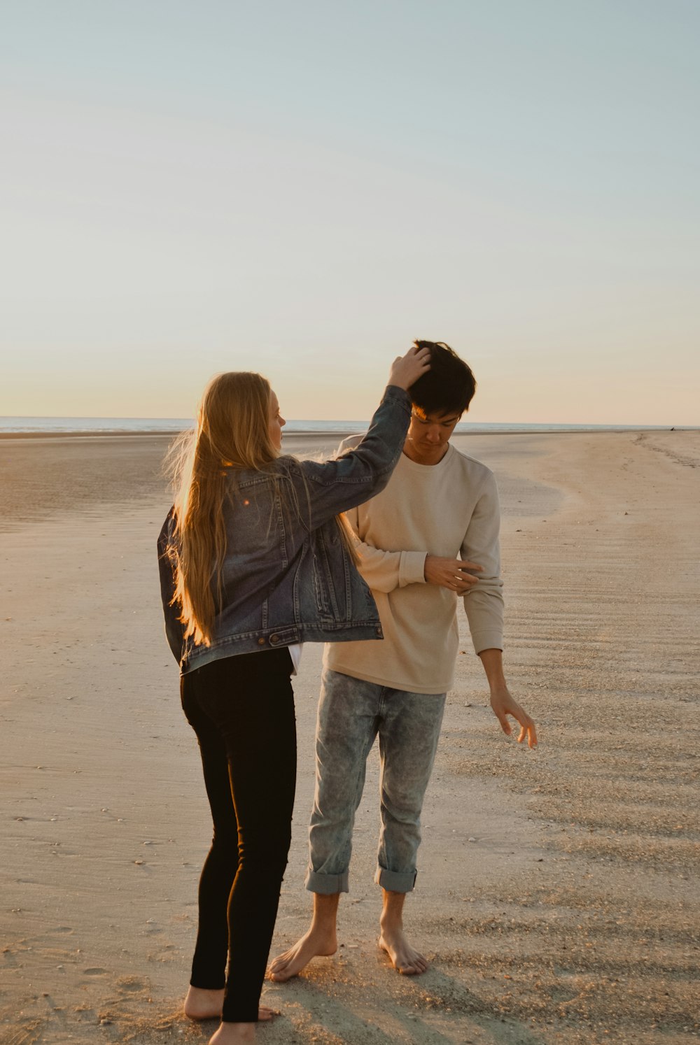 pareja de pie sobre la arena durante el día